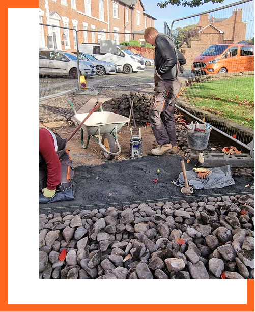 Cobblestone being laid by stonemasons