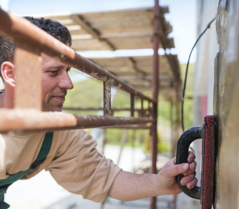 Man putting natural stones on a wall